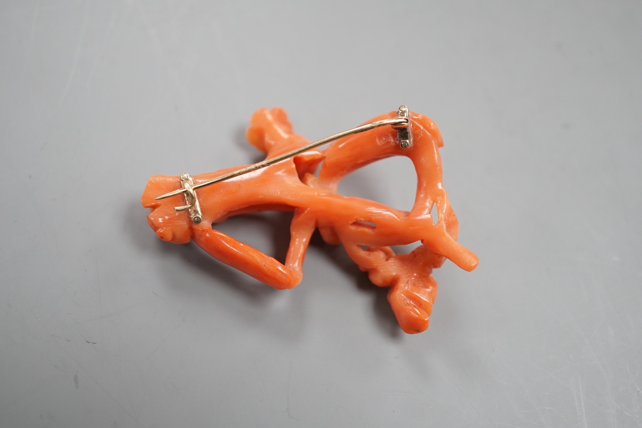 A yellow metal mounted coral 'floral knot' brooch, 56mm.